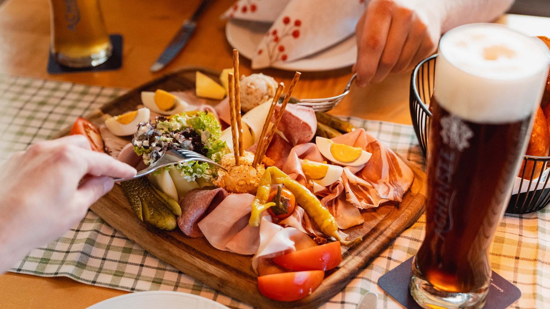 Unser Langlaufstüberl in Pertisau Brotzeitbrett mit Wurst, Käse, Eiern, Gemüse und zwei Gläser Bier