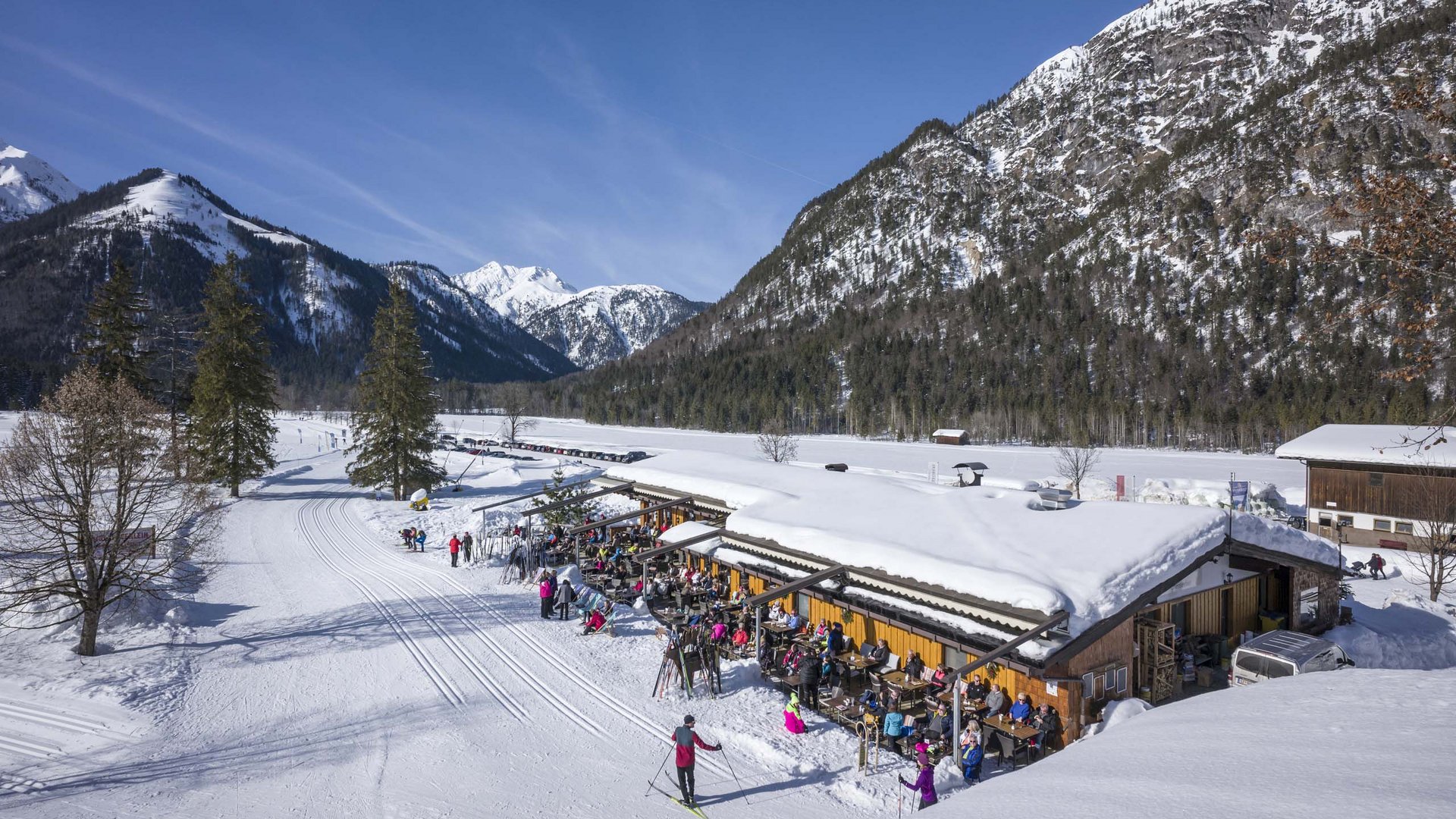 Unser Langlaufstüberl in Pertisau Skilangläufer und Menschen vor einer Hütte in schneebedeckter Berglandschaft