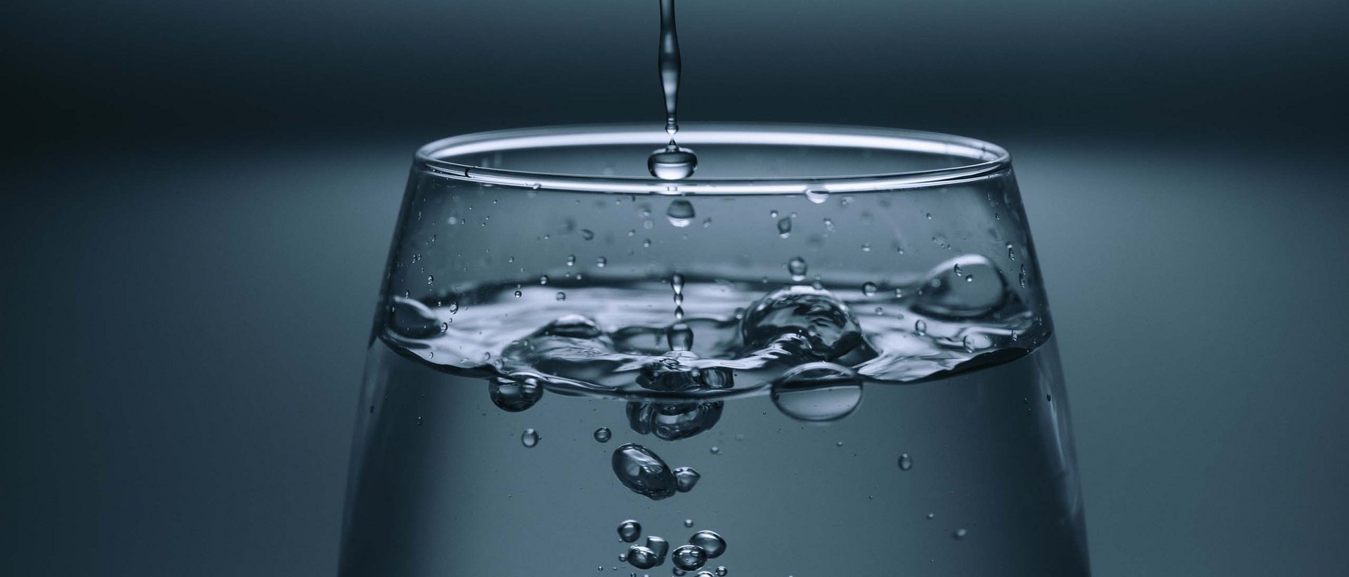 Karwendel-Quellen Wasser tropft in ein Glas und erzeugt Blasen im Wasser