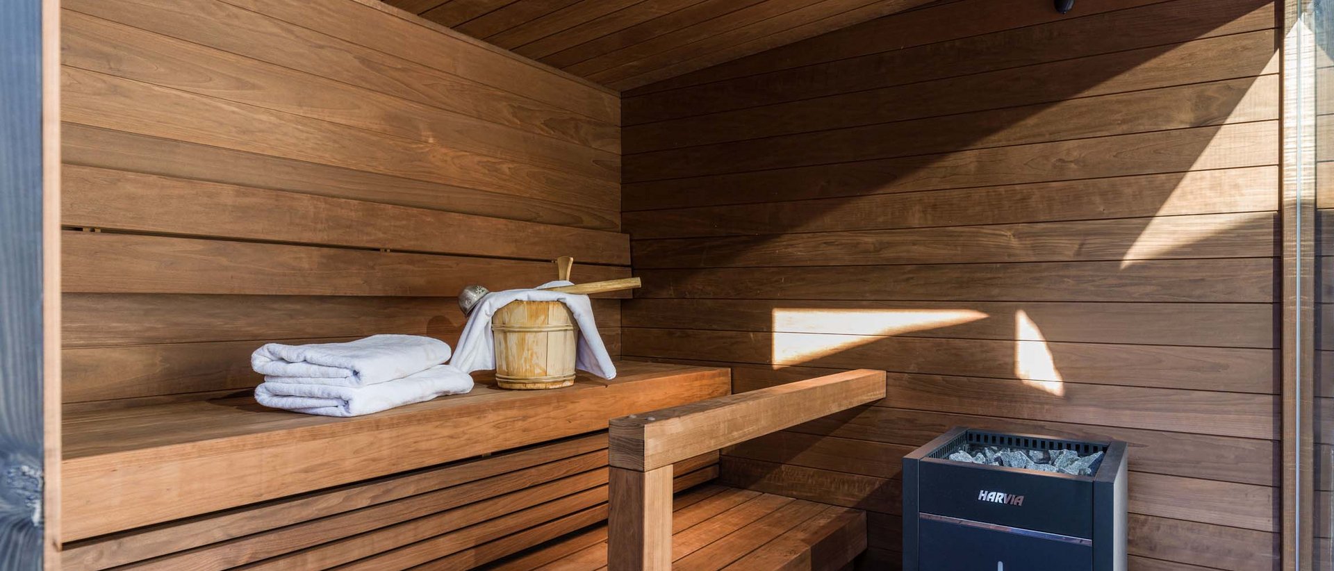 Wohltuende Wärme Moderne Sauna mit Holzbanken, Handtüchern und Blick auf schneebedeckte Landschaft