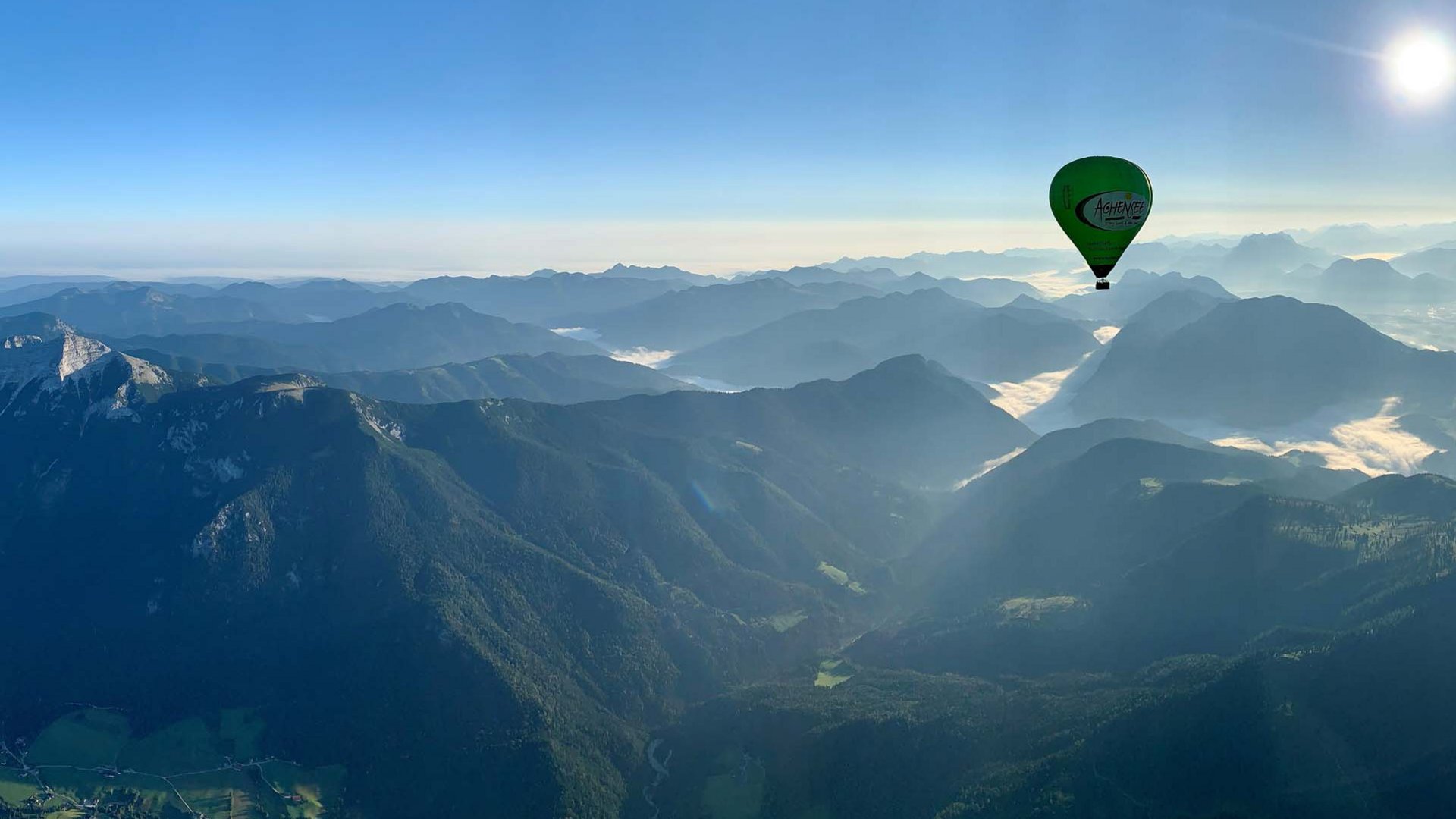 Our hotel on Lake Achensee with swimming pool Hot air balloon over misty mountains in sunlight