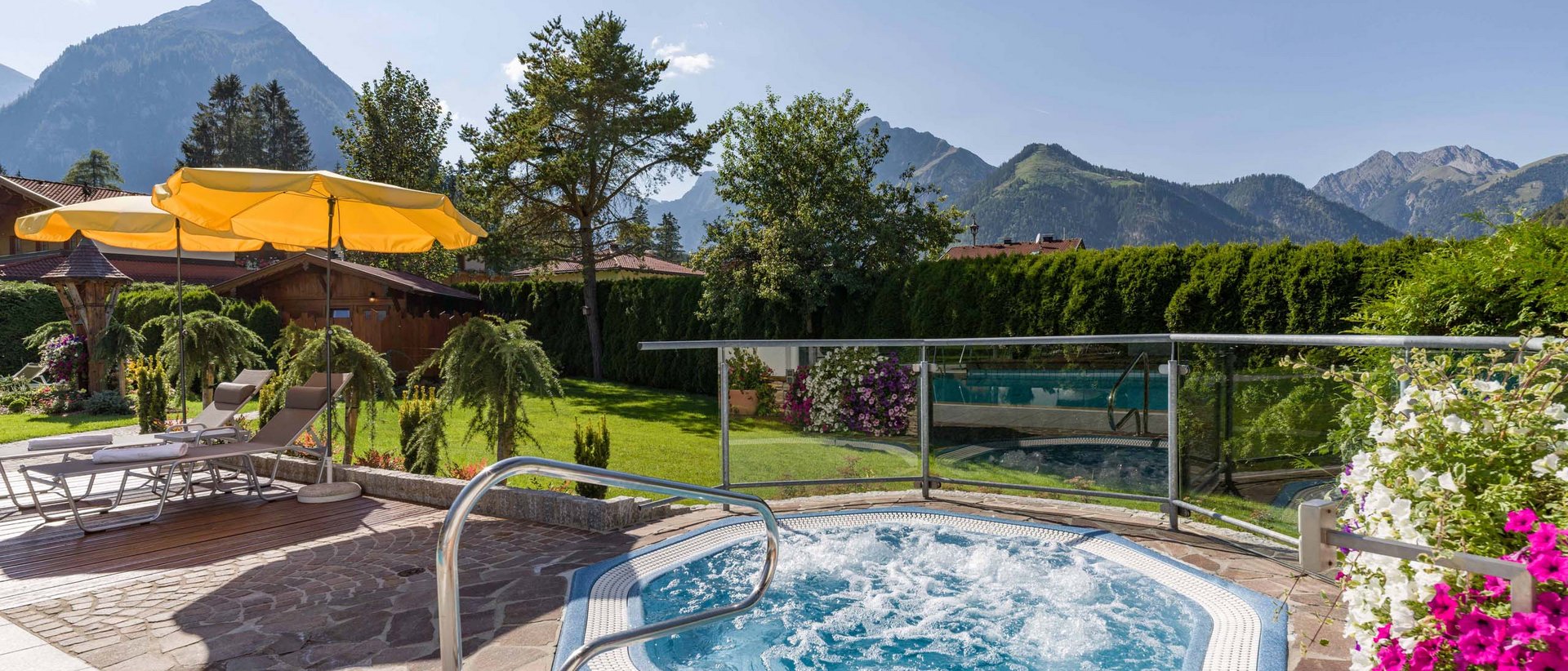 Blubbern im Whirlpool Whirlpool mit Bergblick, Liegestühlen und Sonnenschirmen im Garten