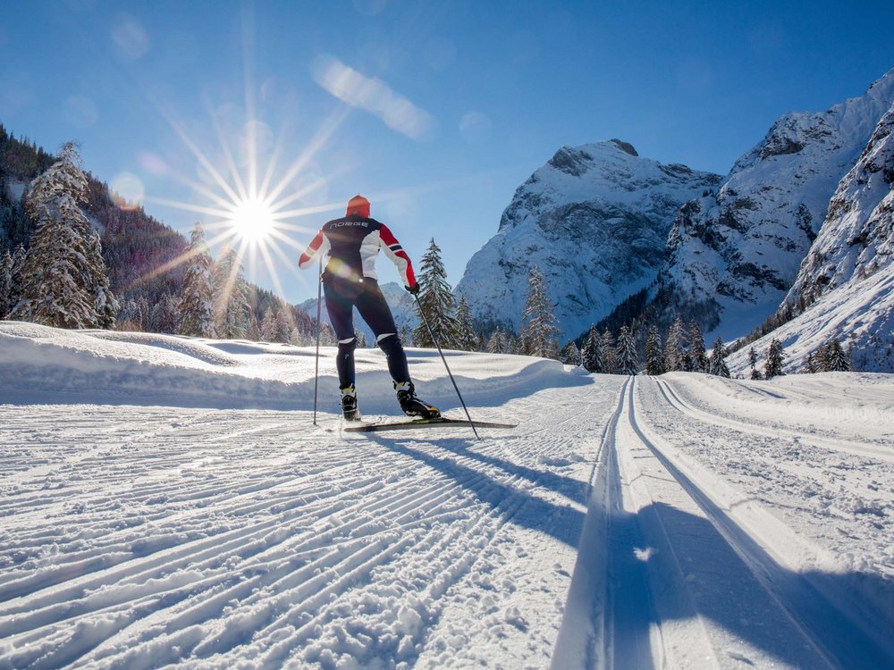 Skifahren am Achensee und mehr Langläufer im Winter auf verschneiter Spur mit Bergen und Sonne im Hintergrund