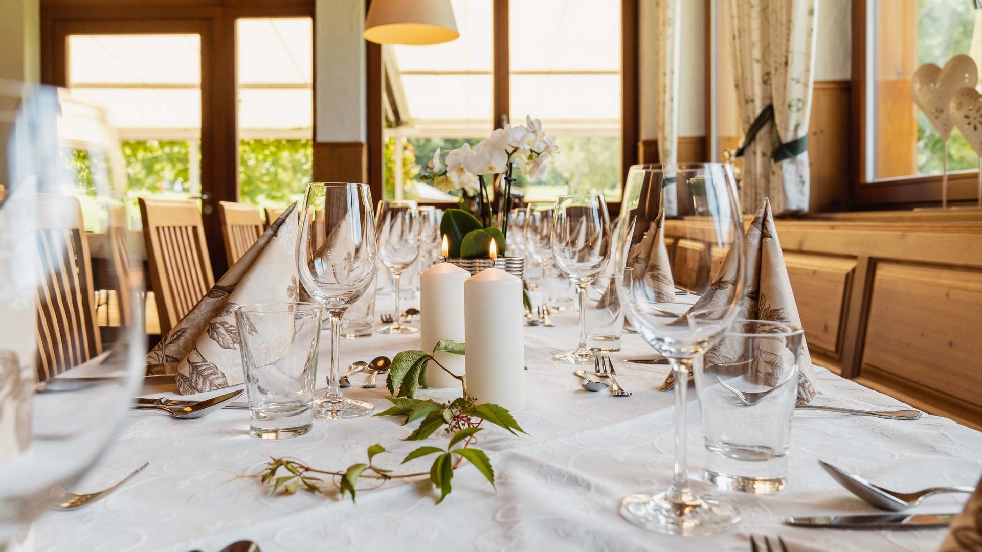 Das Restaurant am Achensee: Karlwirt Weiß gedeckter Tisch mit Kerzen und Weingläsern in einem gemütlichen Raum