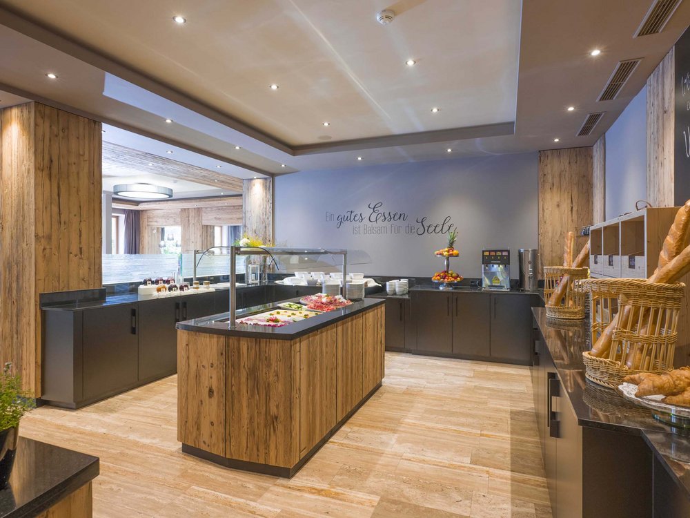 Your restaurant on Lake Achensee: the Karlwirt Modern breakfast buffet area with wood accents and various breads and fruit