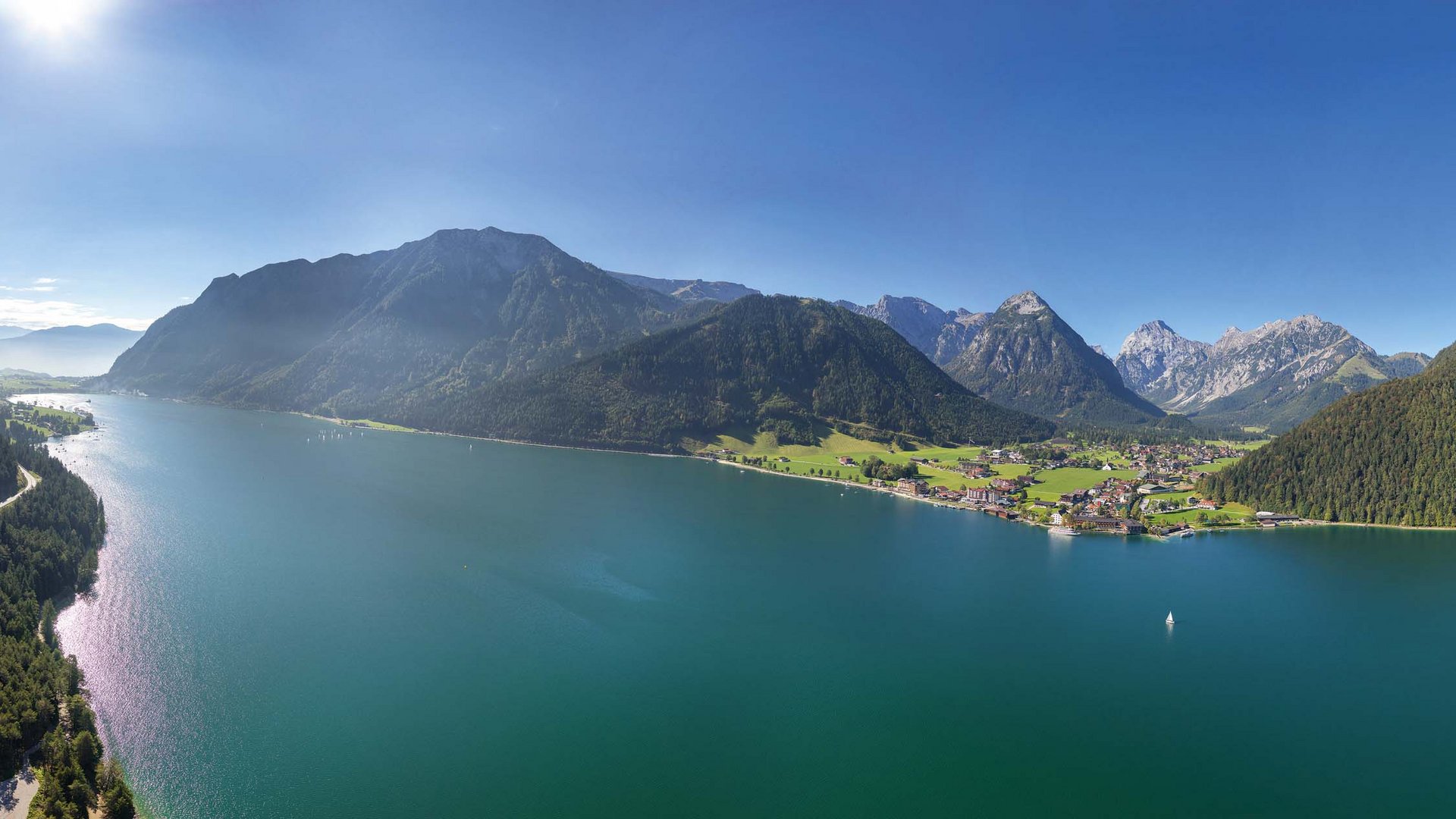 Hotel on Lake Achensee? The Karlwirt! Panoramic view of lake with mountains and villages under clear sky