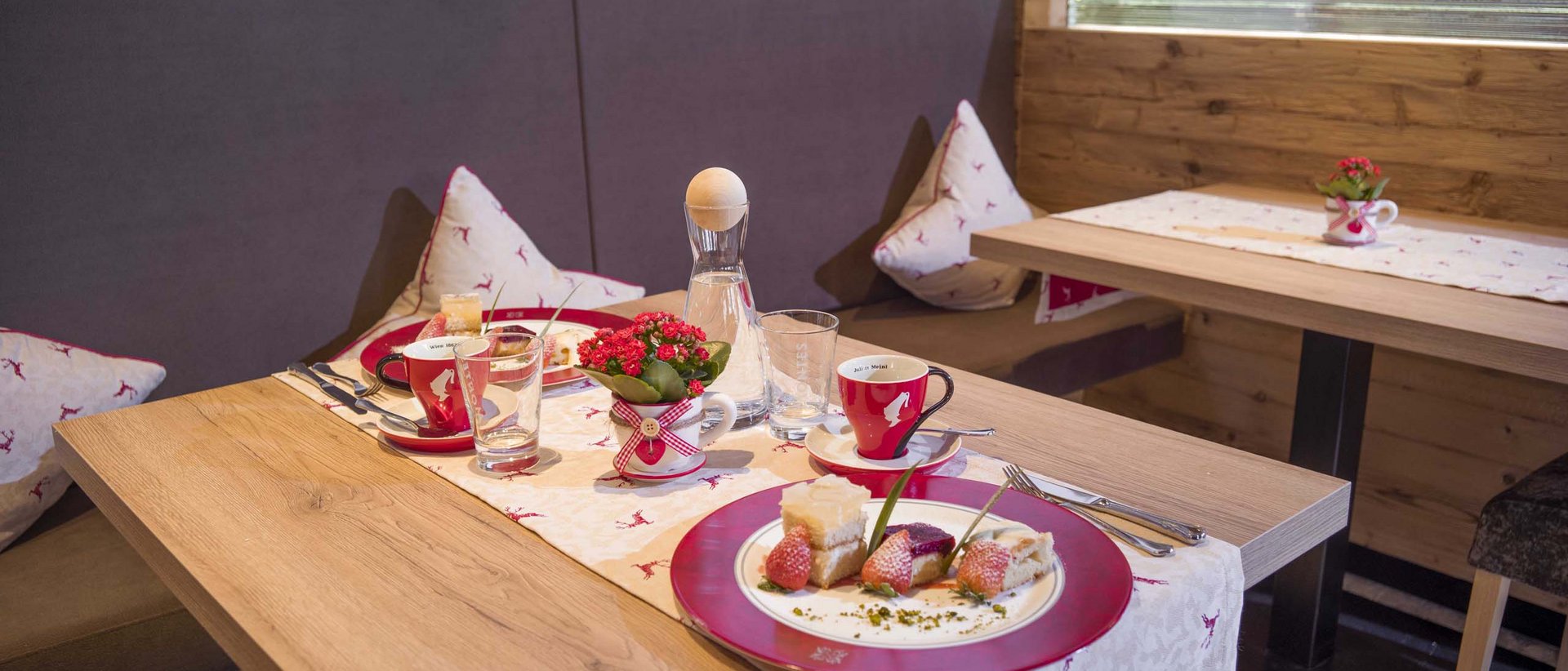 Gutes Essen – Balsam für die Seele Rustikaler Frühstückstisch mit Kuchen, Kaffee und Blumendekoration im Holzzaum