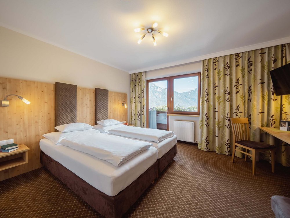 4-Sterne-Hotel am Achensee in Pertisau Gemütliches Hotelzimmer mit zwei Einzelbetten und Bergblick durch das Fenster