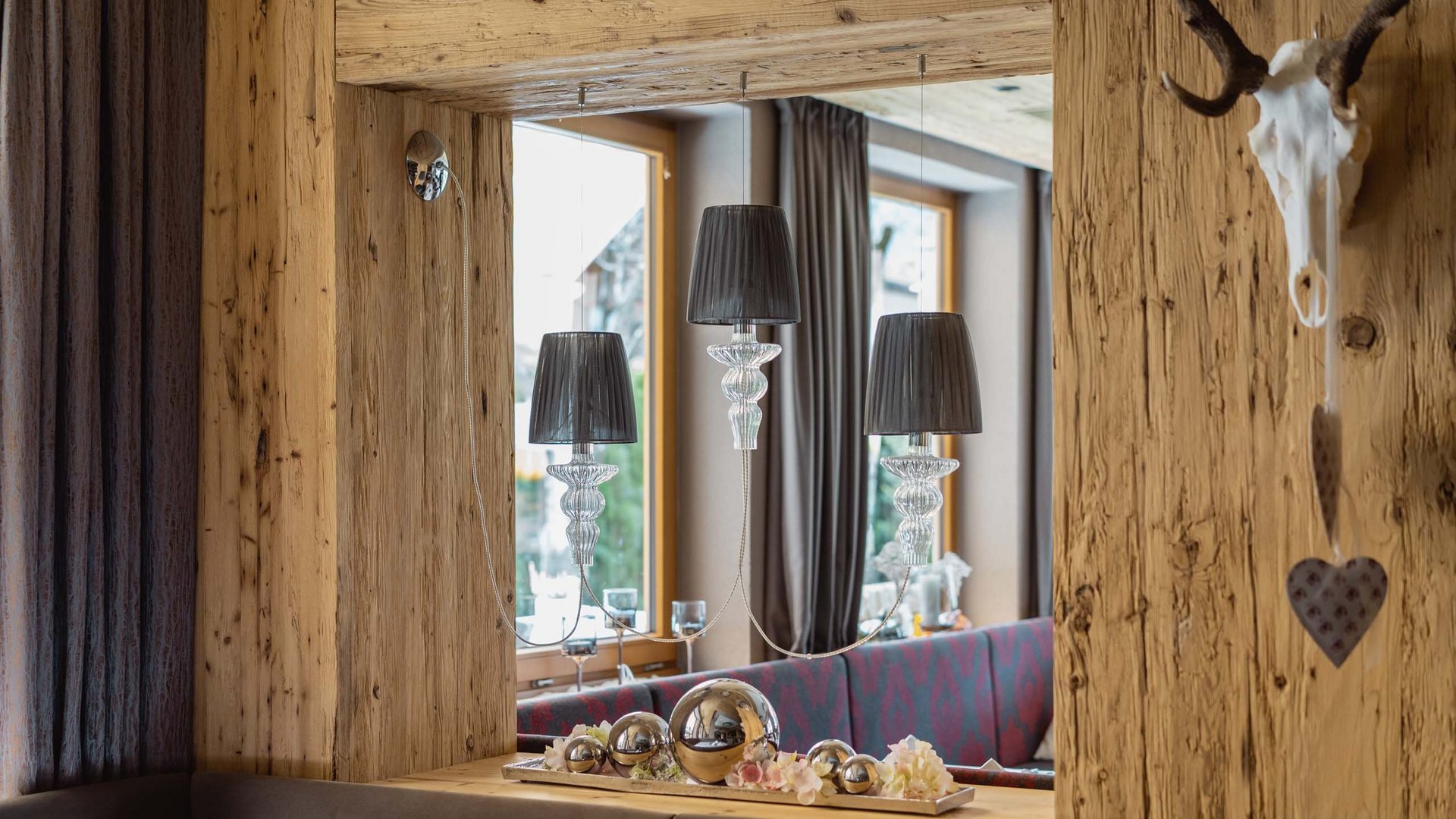 Das Restaurant am Achensee: Karlwirt Gemütliche Rustikal-Wohnzimmer mit Holzvertäfelung und dekorativen silbernen Kugeln