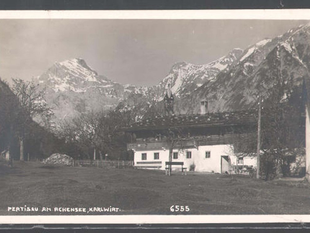 The Karlwirt on Lake Achensee: our history Historical photo of Pertisau at Achensee with mountains and a house