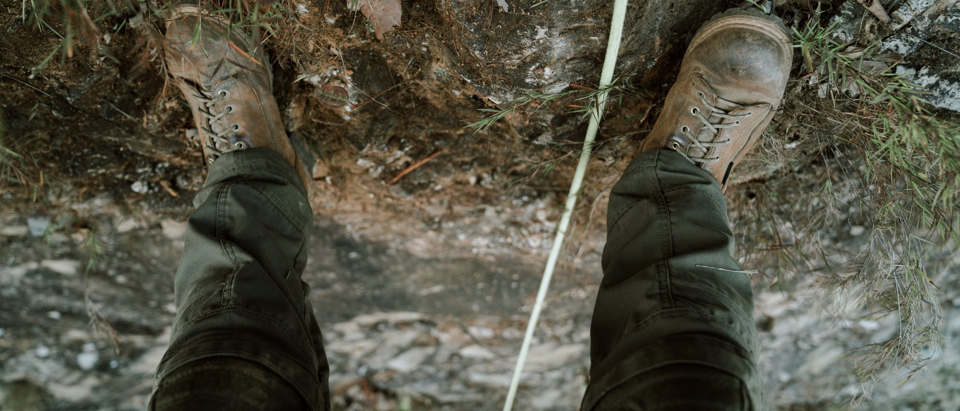 Ein Gipfelerlebnis der besonderen Art Person trägt Stiefel und Hose auf felsigem Boden mit Kletterseil