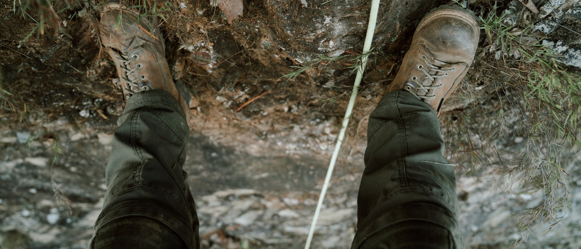Ein Gipfelerlebnis der besonderen Art Person trägt Stiefel und Hose auf felsigem Boden mit Kletterseil