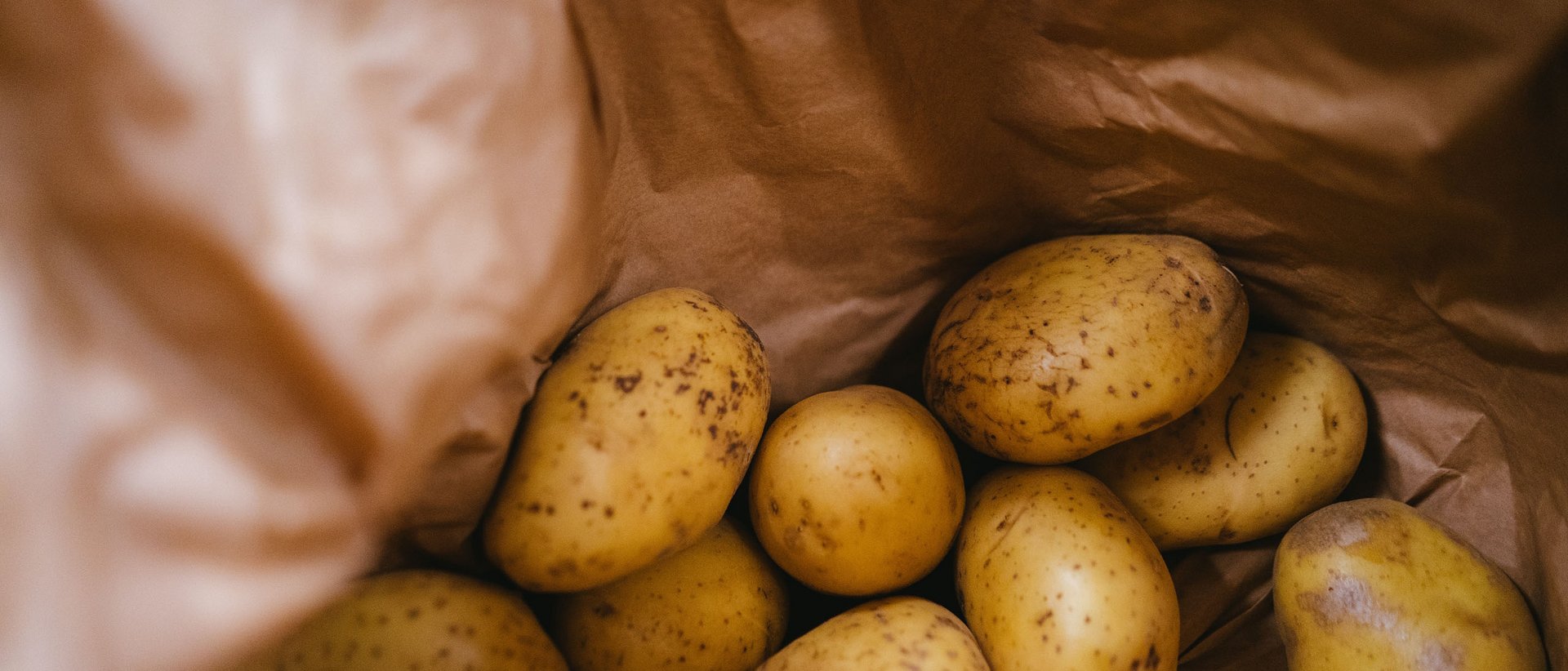 Die Tiroler Gröstl Frische Kartoffeln in einer braunen Papiertüte