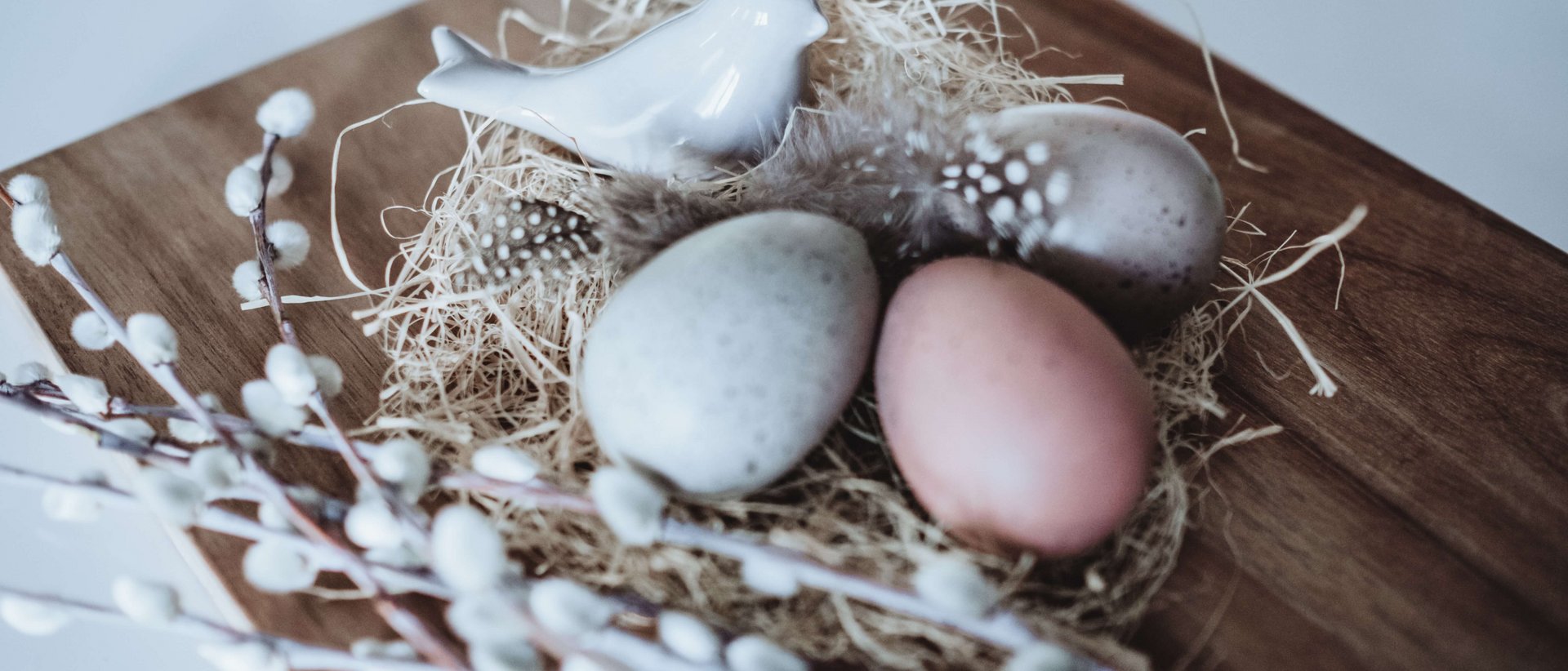 Die wahrscheinlich schönste Zeit des Jahrs Ostertischdeko mit Keramikvogel, gefärbten Eiern und Weidenkätzchen